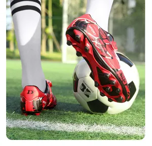 Gros plan détaillé de chaussures de foot enfant avec semelle à crampons antidérapante rouge
