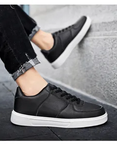 Close-up of black low-top retro sneakers with white soles worn with casual black jeans.