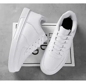Detailed view of white retro low-top skateboard sneakers on a grey textured floor