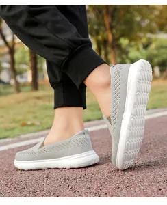 Detailed side view of grey breathable mesh slip-on walking shoes on an outdoor running track