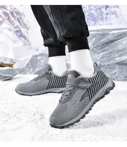 Nahaufnahme von grauen, gefütterten Winter-Wanderschuhen in einer verschneiten Landschaft