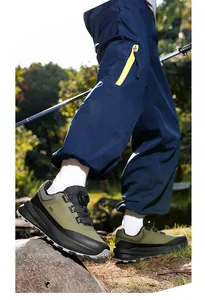 Detalle de zapatillas de senderismo para hombre con cierre giratorio en roca natural.