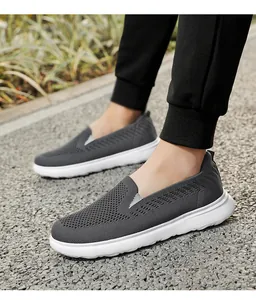 Close-up detail of breathable dark grey fly knit slip-on walking shoes on a paved path