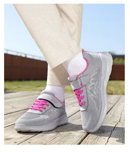 Primo piano di scarpe da camminata in mesh grigio e rosa su un ponte in legno esterno.