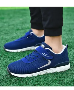 Close-up of blue breathable mesh walking shoes on green grass for outdoor sports.