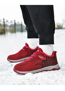 Rote Fly-Knit Wintersneaker mit warmem Kunstfellfutter und Klettverschluss auf Schnee