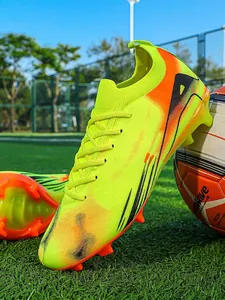 Vibrant lime yellow and orange professional soccer cleats for training on turf field
