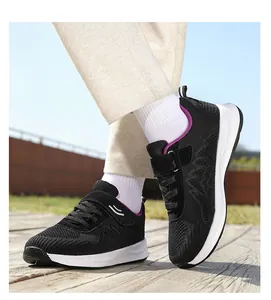 Dettaglio ravvicinato delle scarpe da passeggio in maglia nera su una pedana in legno