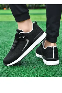 Close-up of lightweight black knit walking sneakers for men and women on green grass