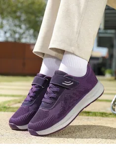 Vista laterale dettagliata delle sneakers da passeggio viola leggere e traspiranti.