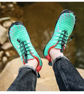 Gedetailleerde close-up van ademende mintgroene waterschoenen gedragen op rivierstenen.