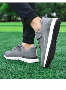 Detail view of lightweight grey mesh walking shoes with Velcro straps on green grass.
