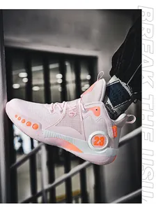 Détail latéral d'une chaussure de basket rose avec logo 23 et orange.