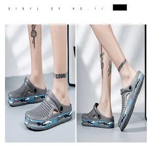 Seitenansicht grauer Garten-Clogs mit blauem Camouflage-Sohlendetail an den Füßen