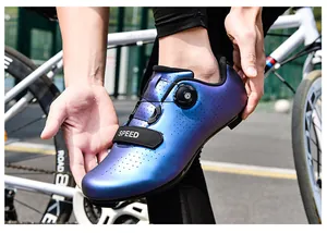 Primer plano de zapatilla de ciclismo azul degradado con cierre giratorio y correa.