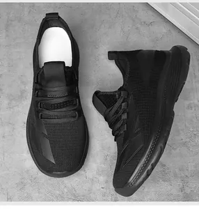 Draufsicht auf schwarze Mesh-Laufschuhe mit dicker Dämpfungssohle auf grauem Grund