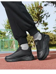 Detailed view of black leather slip-on walking shoes for elderly on a running track.
