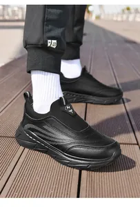 Detailed view of black leather slip-on walking shoes for elderly on wooden floor