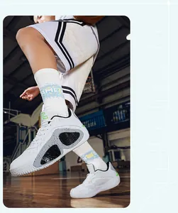 Detailed action shot showing white low-top mesh basketball shoes on a wooden court floor