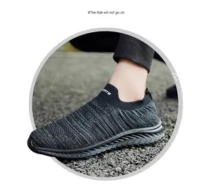 Detailed close-up of breathable grey flyknit slip-on sports sock shoes worn on gravel
