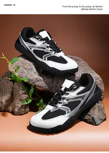 Vista detallada de zapatillas de entrenamiento de malla blancas y negras en rocas