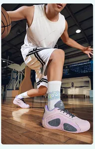 Close-up of pink and grey mesh basketball shoes on a wooden basketball court during play