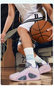 Detailed view of pink low-top basketball sneakers in a dynamic court setting.