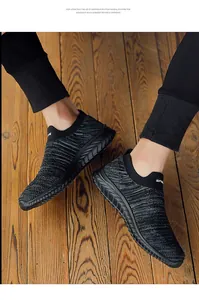 Close-up detail of breathable grey flyknit slip-on sock sneakers on wooden floor