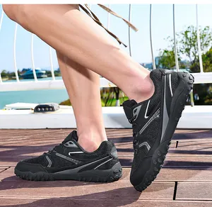 Primer plano de zapatillas de entrenamiento de malla negra en una plataforma de madera.
