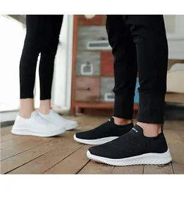 Detailed view of breathable black and white knit slip-on sneakers for active couples.