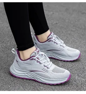 Close-up of grey breathable mesh running shoes with purple accents on pavement