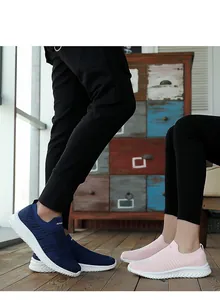 Couple wearing breathable mesh slip-on sock shoes in navy blue and pink for running.