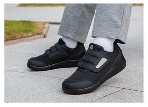 Close-up of black walking sneakers with triple velcro straps and breathable mesh fabric.
