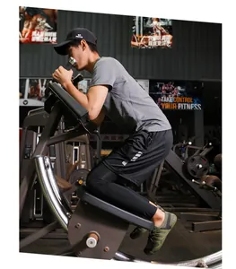Man wearing green mesh aqua shoes while exercising in a gym setting