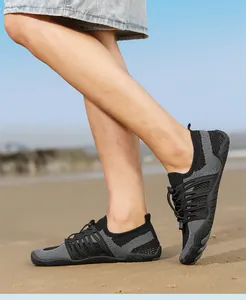 Detail view of breathable mesh water shoes worn on a sandy beach for outdoor sports
