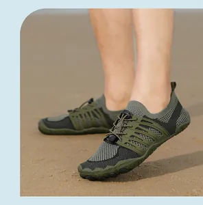 Detail view of army green mesh wading shoes with quick-drying drainage design on sand.
