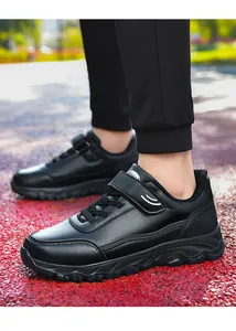 Close-up of black leather walking shoes with Velcro straps for seniors outdoors