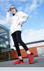 Detail view of red and black gradient fly-knit running shoes in an outdoor urban setting