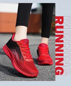 Close-up of red and black mesh flying woven running shoes on model's foot in motion.