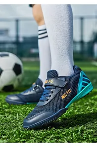 Gros plan de chaussures de football pour enfants bleu marine avec mesh et semelle turf