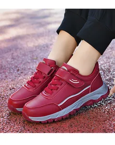 Close-up detail of burgundy leather walking sneakers featuring Velcro strap and durable sole