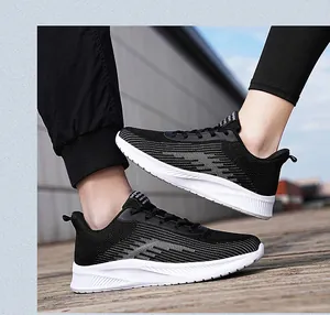 Dynamic side view of breathable black fly-knit running shoes on outdoor wooden deck