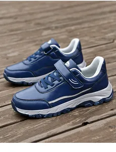 Side view of navy blue leather walking shoes on a rustic wooden deck background
