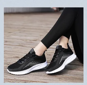 Detail view of black flying woven mesh running shoes worn on a wooden boardwalk
