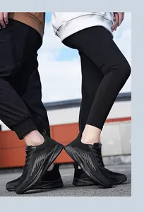 Detail of breathable black knitted sneakers for men and women in an outdoor urban setting