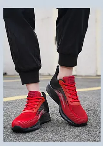 Detailed view of breathable red and black fly-knit running shoes with mesh texture