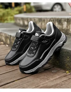 Detail shot of black leather walking shoes with secure hook and loop fastener straps.
