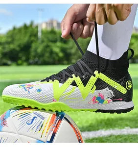 Detailed view of an athlete tying the laces of colorful high-top soccer shoes outdoors
