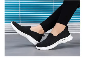 Vista lateral de zapatillas de caminar fly-knit negras transpirables con suela deportiva