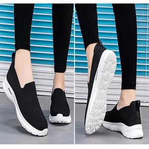 Detalle de las zapatillas sin cordones de malla transpirable negra con suelas blancas.